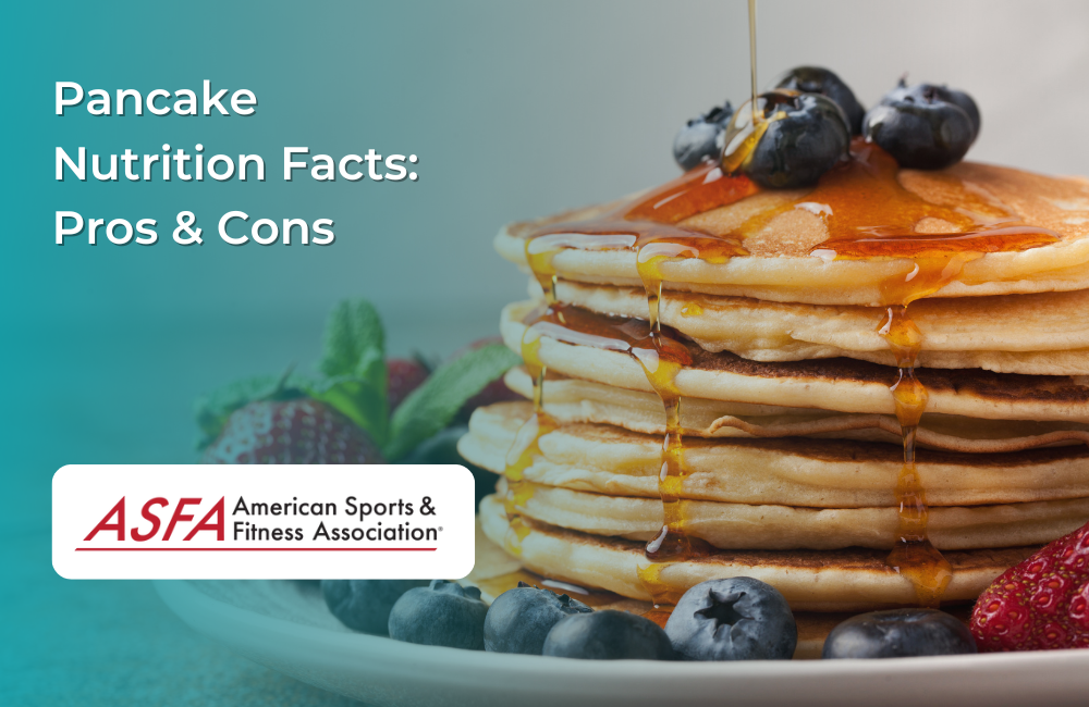 A stack of golden pancakes topped with blueberries and drizzled with syrup, served on a white plate with fresh fruit.