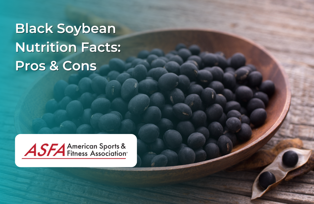 A wooden bowl filled with black soybeans placed on a rustic wooden surface, with a few soybeans scattered around.