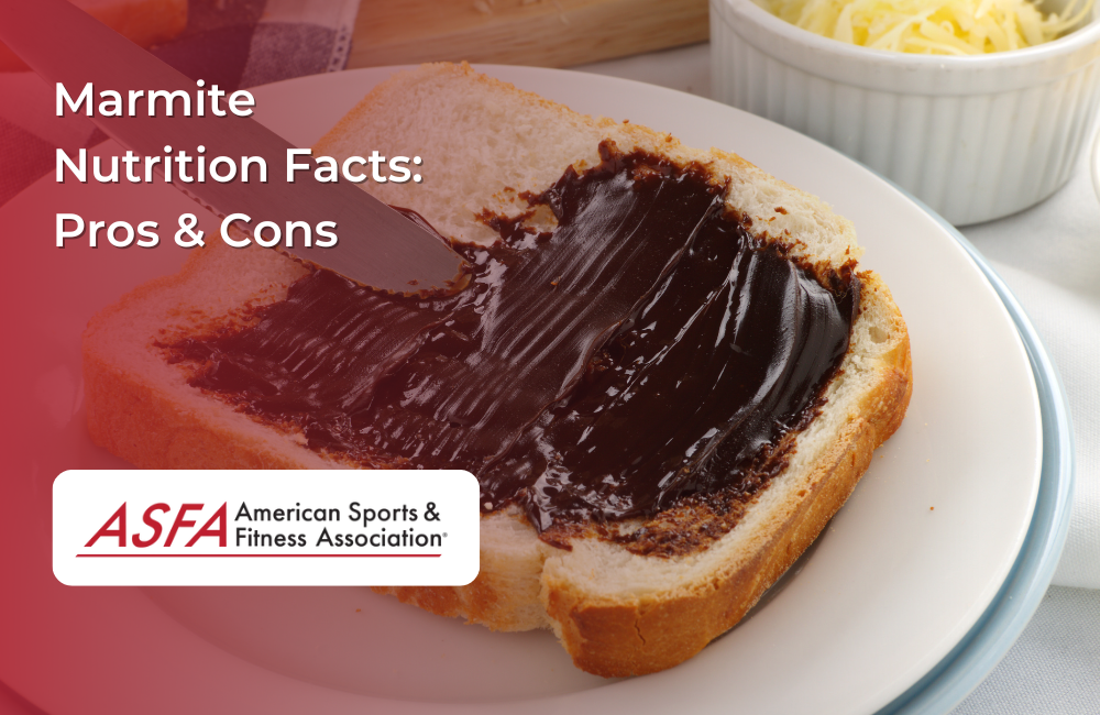 A slice of bread with a thick spread of Marmite, with a knife spreading it and a bowl of grated cheese in the background.