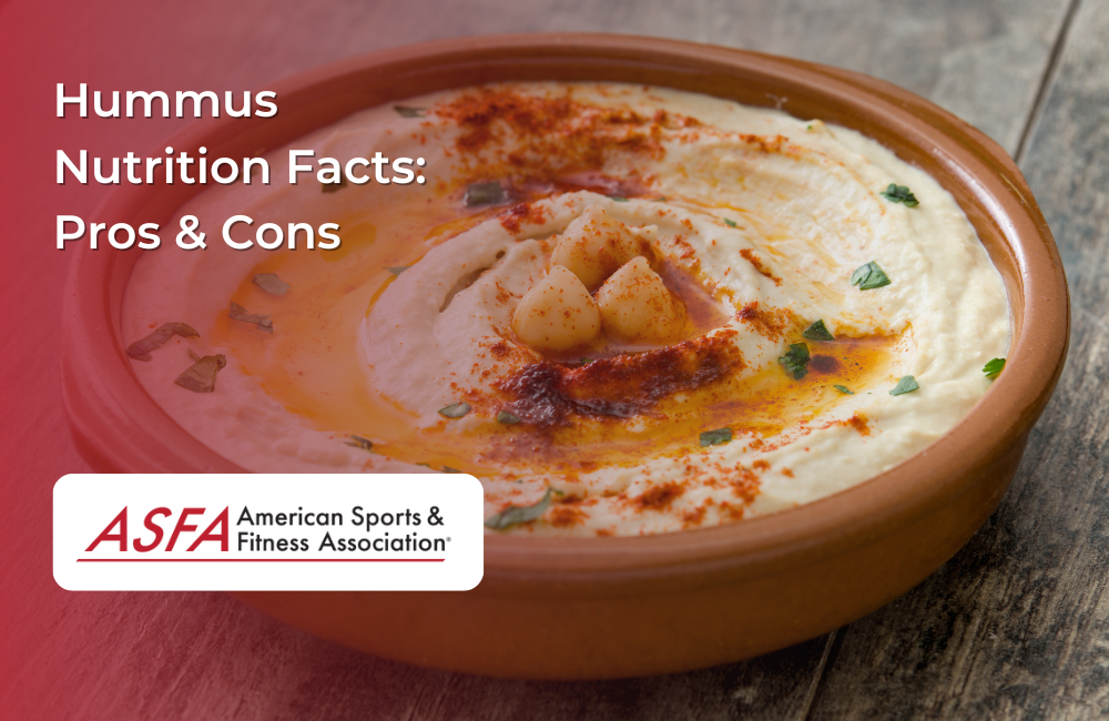 A bowl of creamy hummus drizzled with olive oil, garnished with chickpeas, paprika, and parsley.