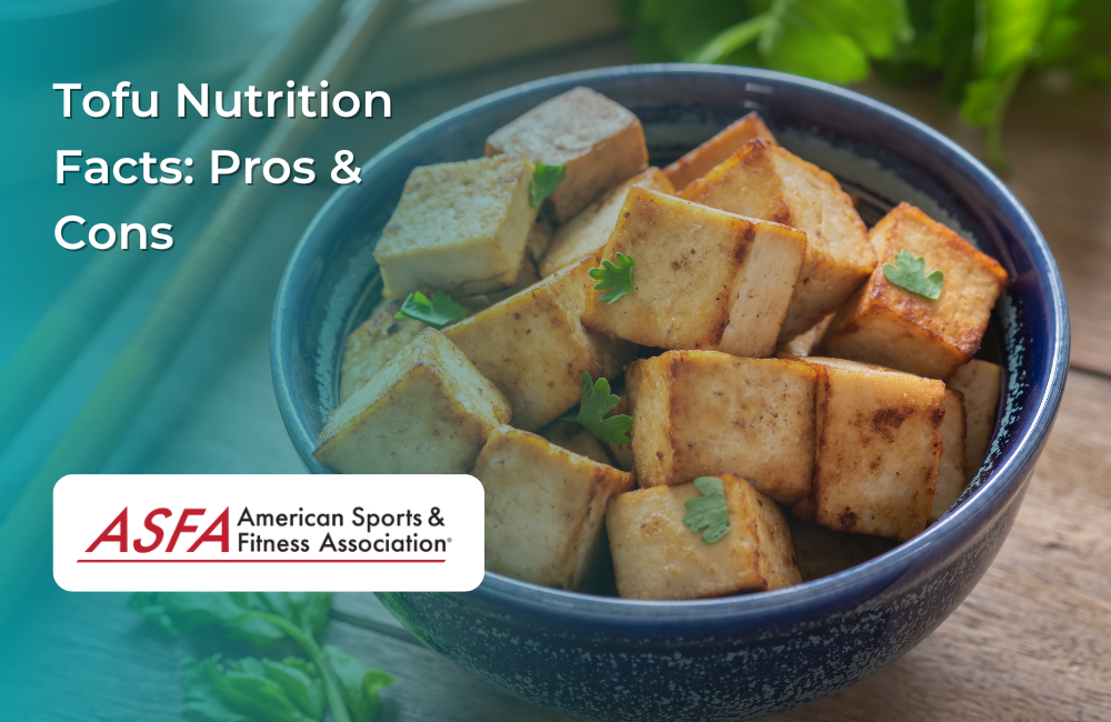 A bowl of golden-brown grilled tofu cubes garnished with small green parsley leaves, set on a wooden surface.