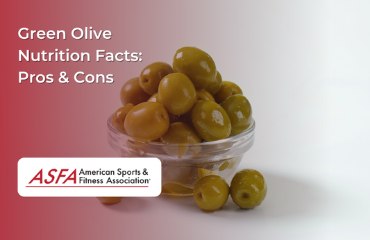 A glass container holding green olives, with more olives scattered around it.