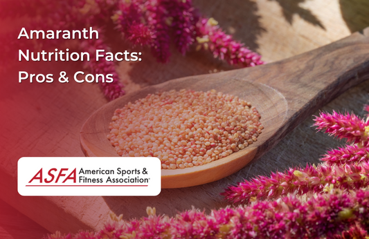 A wooden spoon filled with small amaranth grains, surrounded by pink amaranth flowers.