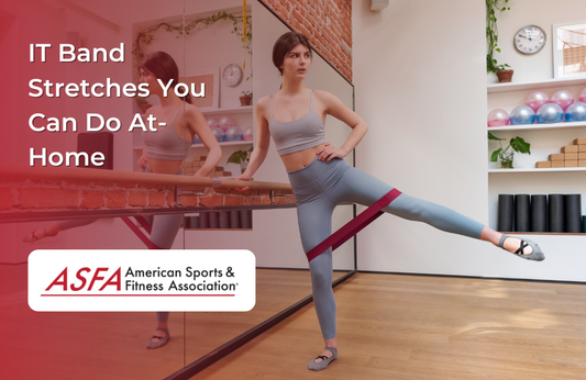 A woman performing a side leg stretch with a resistance band in a studio, using a mirror for balance.