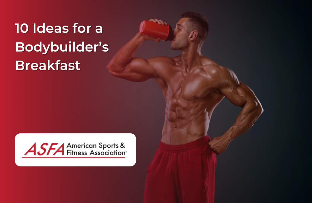 A man in red shorts drinking a protein shake out of a red bottle while he is standing against a dark background.