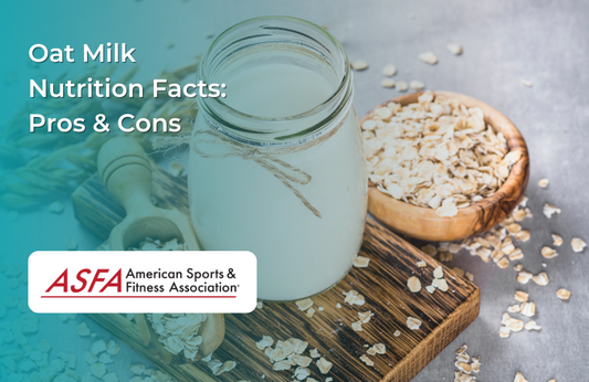 A glass jar filled with oat milk surrounded by oats on a rustic wooden surface.