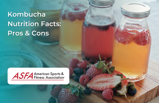 Bottles of kombucha infused with berries on a wooden surface with fresh fruit.