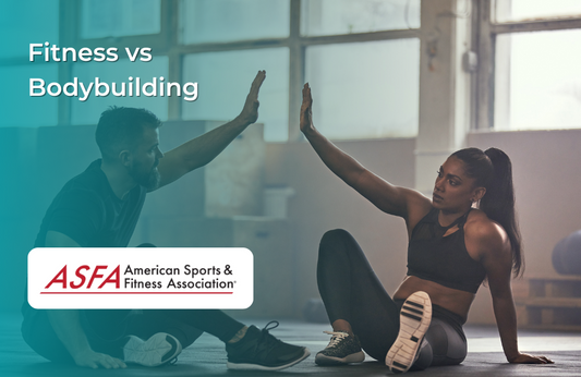 A man and woman seated on a gym floor mid-exercise, high-fiving each other as part of a workout session.