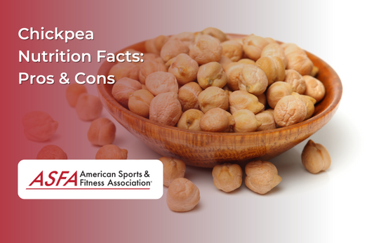 A wooden bowl filled with dried chickpeas, with a few scattered around on a white surface.