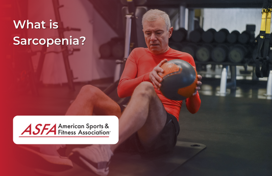 Elderly man performing russian twists with weighted ball in a gym.