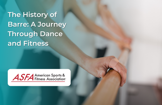 Hands gripping a wooden barre in a fitness studio with people in the background.