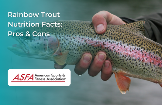 A freshly caught rainbow trout being held above a body of water.