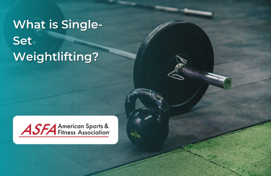 A barbell and a kettlebell rest on a gym floor, ready for a weightlifting session.