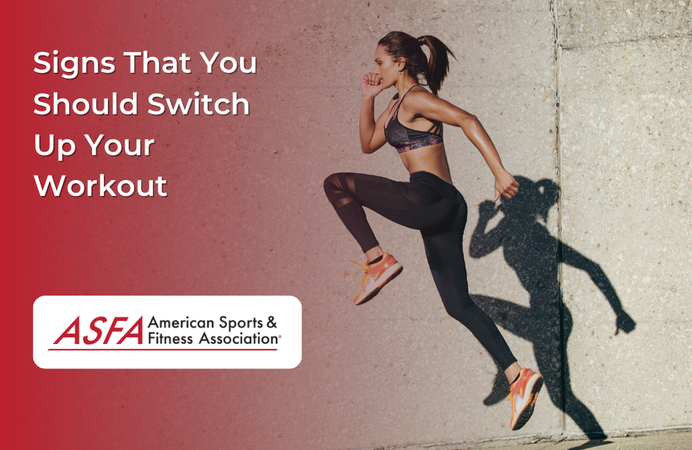 A woman in athletic wear mid-jump against a concrete wall.