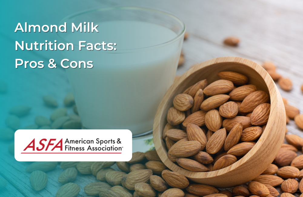A glass of almond milk with a bowl of almonds on a wooden surface.