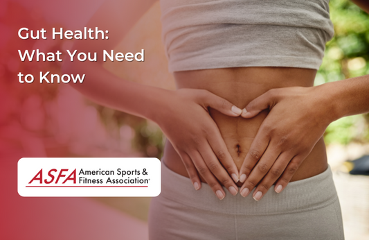 A woman in athletic wear forming a heart shape with her hands over her stomach