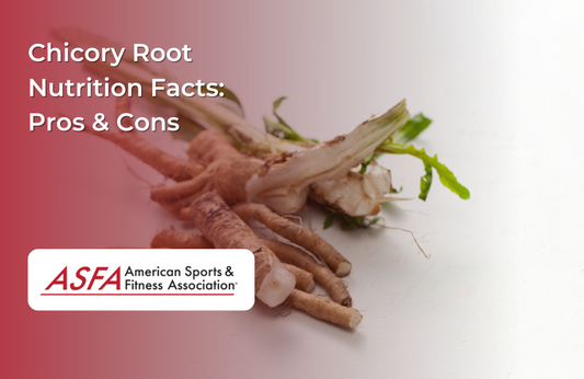 Fresh chicory roots with green leaves still attached on a white surface.