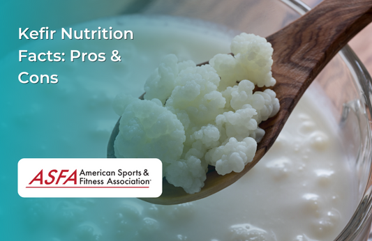 A wooden spoon holding kefir grains over a bowl of kefir milk.