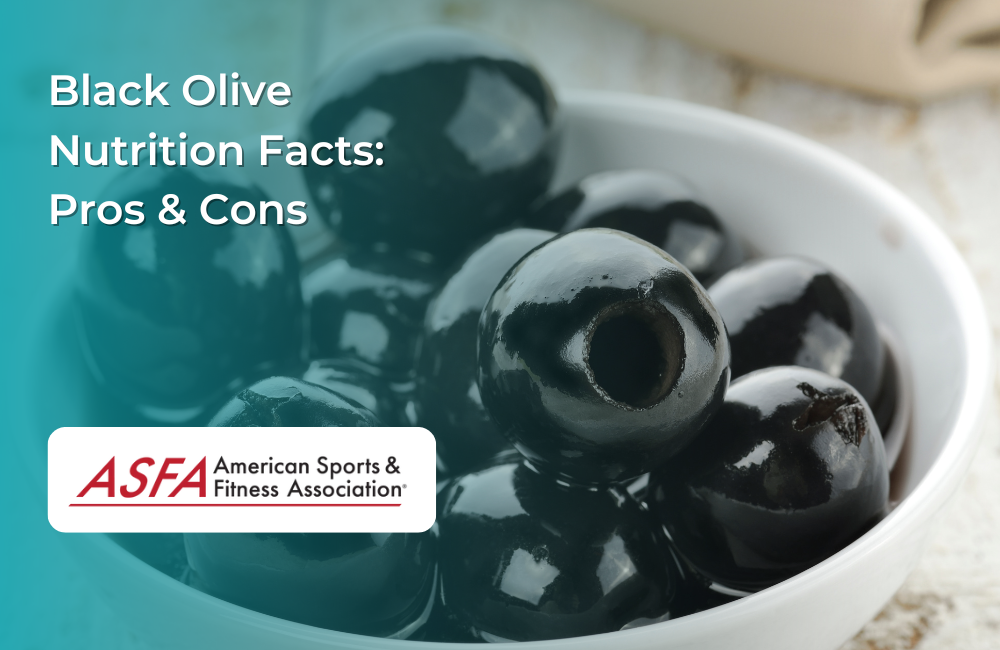 A white bowl filled with glossy black olives, with some olives slightly overlapping the bowl.