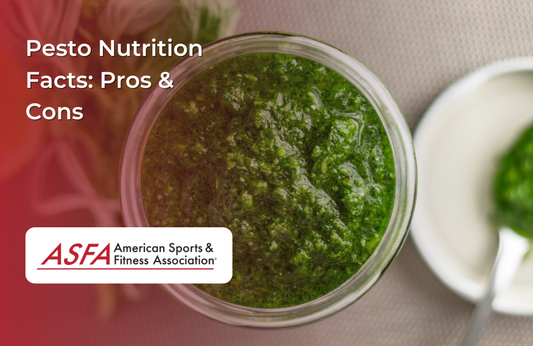  A jar of green pesto sauce, placed on a table with a small dish of sauce beside it.