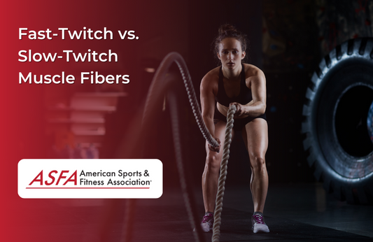 A woman in workout clothes using battle ropes in a gym, with a tire in the background.