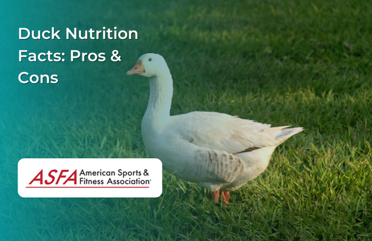 A white duck standing on a grassy field.