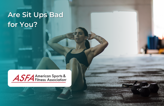 A lady in a black shirt doing sit ups in a low lit gym.