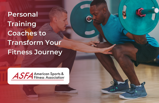 A trainer crouches in front of a man performing a barbell squat in a gym.