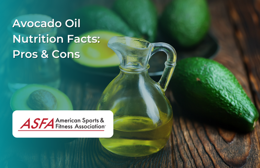 A glass bottle of avocado oil next to fresh avocados on a rustic wooden surface.