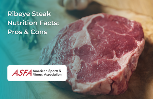 A raw ribeye steak on a wooden surface with seasoning.