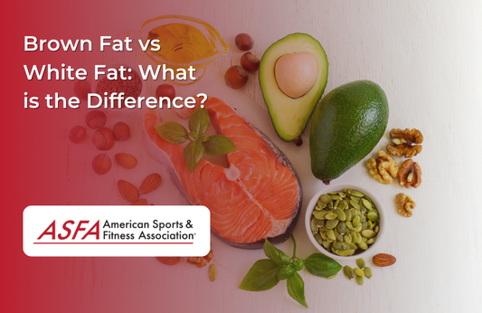 A salmon steak with a cut avocado, nuts, fresh basil leaves, and a lemon wedge around it on a white surface.