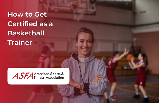 A coach with basketball players playing behind her on an indoor basketball court.